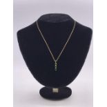 A 9ct gold and emerald three stone pendant with gold neck chain on a bolt ring clasp detailed 375.(