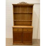 A pine dresser with plate rack/shelves to top and cupboard with drawers to base (H210cm W108cm