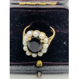 A 9ct gold garnet and seed pearl ring.