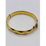 A 9ct gold metal cored bangle