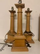 A Set of three wooden pillar style candlesticks