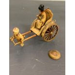 An ivory/resin figure of a boy pulling a rickshaw