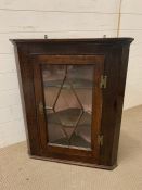 A Two Shelf Glazed corner cabinet with brass furniture H 84 cm x W 70 cm x D 34 cm