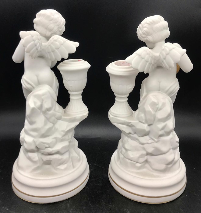 A Pair of Franklin Mint Cherub candlesticks