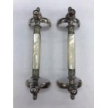 A Pair of decorative knife rests in white metal