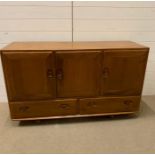 A Mid Century Elm Ercol sideboard with original easy glide castors, double door cupboard and