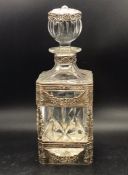 A decorative decanter with white metal frame work to outside