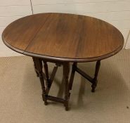 A small gate leg mahogany table on turned legs (H74cm W96cm D63cm)