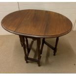 A small gate leg mahogany table on turned legs (H74cm W96cm D63cm)