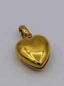 An untested gold metal heart shaped locket