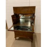 A Mid Century cocktail cabinet with original cocktail sticks and mirror lining