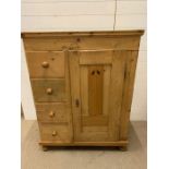 A pine cupboard with doors opening to reveal shelves and drawers to left hand side (H122cm W95cm