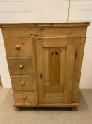 A pine cupboard with doors opening to reveal shelves and drawers to left hand side (H122cm W95cm