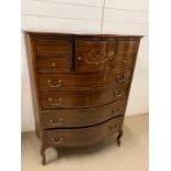 A Serpentine Fronted chest comprising four small drawers and a cupboard over four long drawers