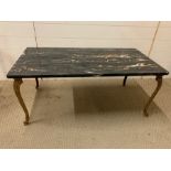 A marble topped coffee table on brass scrolled feet (H43cm W102cm D51cm)