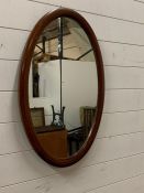 A oval inlaid mahogany mirror (46cm x 72cm)