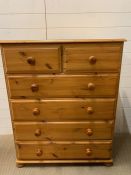 A pine two over four chest of drawers on bun feet (H112cm W90cm D44cm)