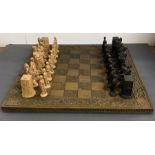 A chess board and large carved pieces
