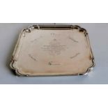 An Art Deco silver presentation tray of square form with stepped rim on four feet by Roberts &