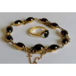 A yellow gold and garnet bracelet with oval cabochons, diamond decoration to clasp, tests for high