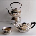 A George V silver boat-shape teapot with ebonised handle and finial, matching cream jug in half