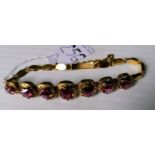 A mid-20th century Burmese garnet and gold bracelet, the seven emerald-cut graduated stones