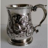 A George II silver baluster mug with scroll handle and later embossed rococo decoration,