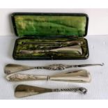 A broad assortment of late Victorian silver-handled button hooks and shoe horns to include a novelty