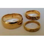 Two gold wedding bands, stamped 15K and an African gold band with tiger decoration, tests for high