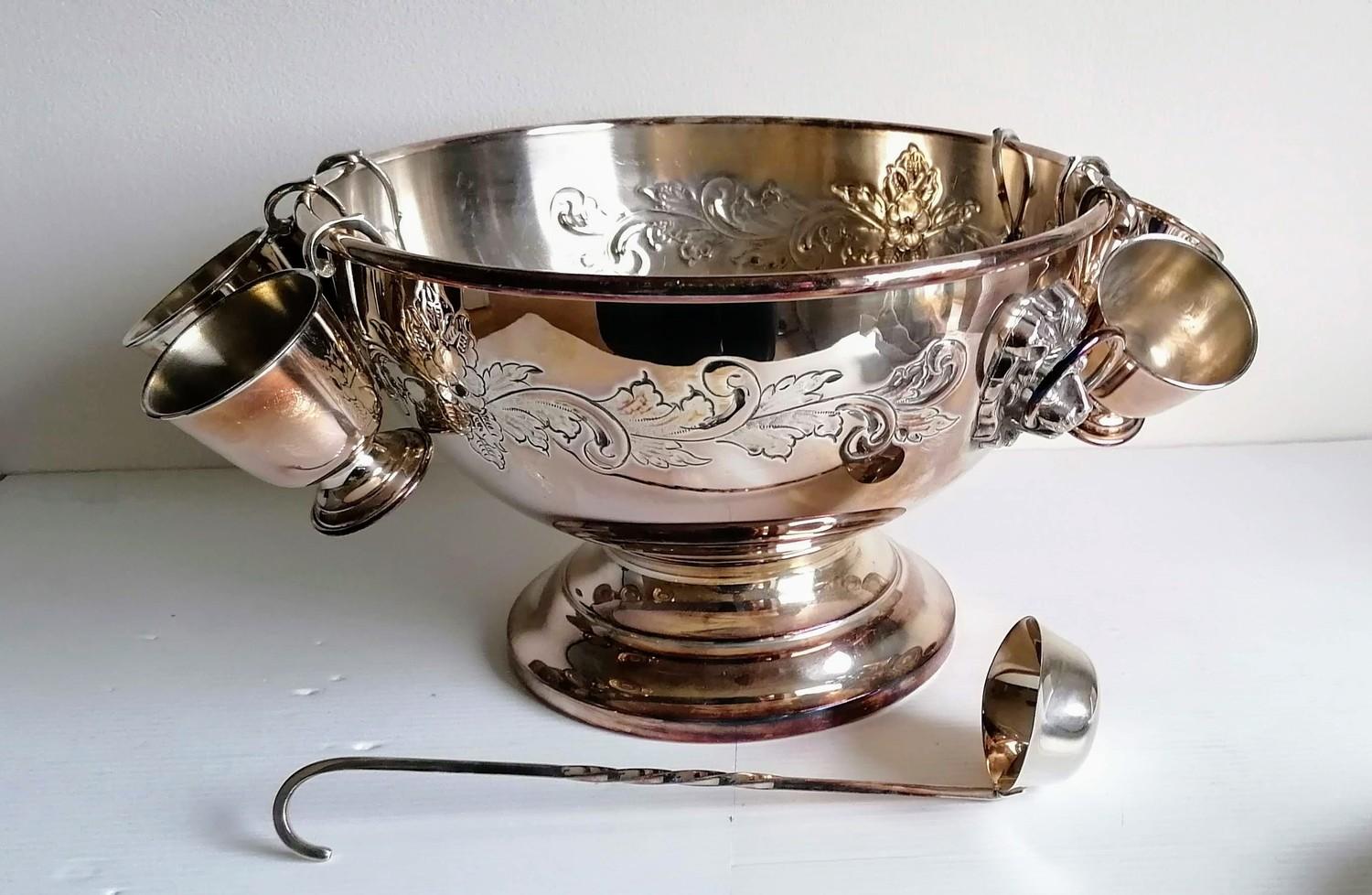 A silver plated punch bowl with lion mask handles, six goblets and a ladle, 20 x 32 cm diameter