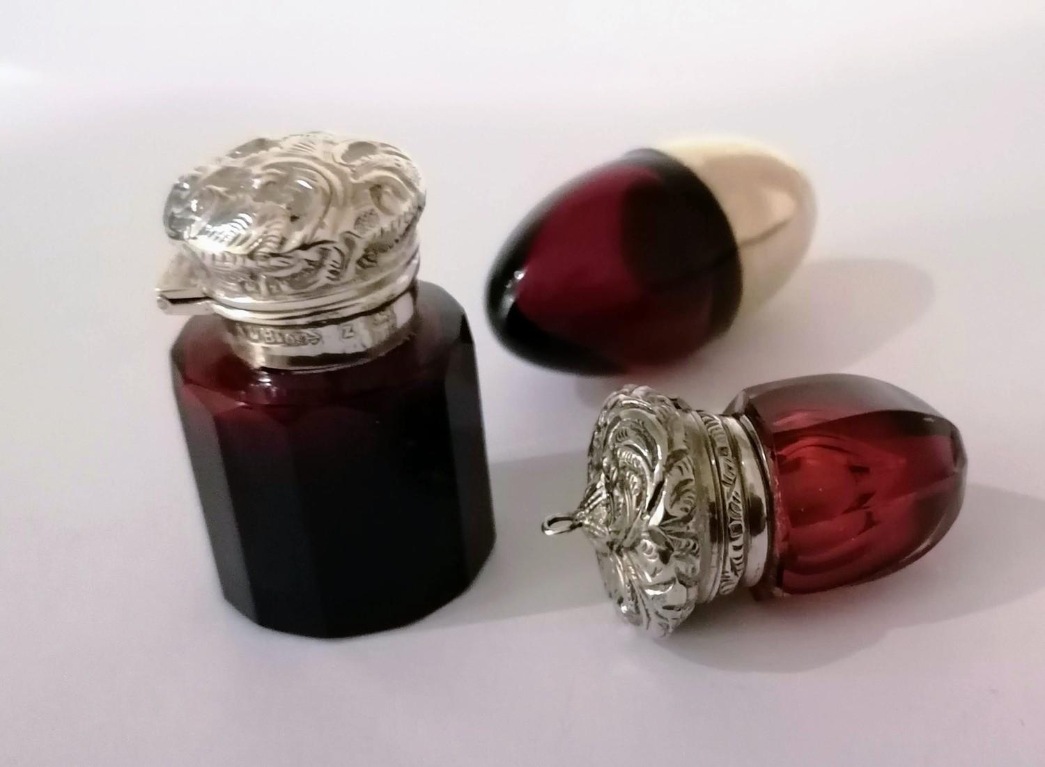 A Victorian silver-topped ruby glass scent bottle with embossed flip-top cap, original stopper by