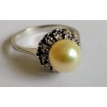 A pearl and diamond cluster ring on an 18ct white gold setting, the untested pearl approx. 7mm