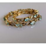 An aquamarine line or tennis bracelet with diamond decoration on 9ct yellow gold, each stone 4mm x