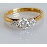 A three-stone diamond ring in a claw setting, the central stone 0.25 carats, on 18ct yellow gold,