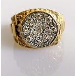 A gold and diamond gents ring, the round dial pave-set with round brilliant-cut diamonds of
