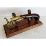 A 19th century eprouvette or gunpowder tester, the mahogany pistol grip with brass barrel, touch