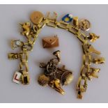 A gold bracelet stamped 585 with a selection of 9ct gold charms, 25.54g and a further group of 9ct