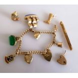 A 9ct gold charm bracelet with three loose charms, gold tooth pick, hallmarked, 36.57g