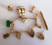 A 9ct gold charm bracelet with three loose charms, gold tooth pick, hallmarked, 36.57g