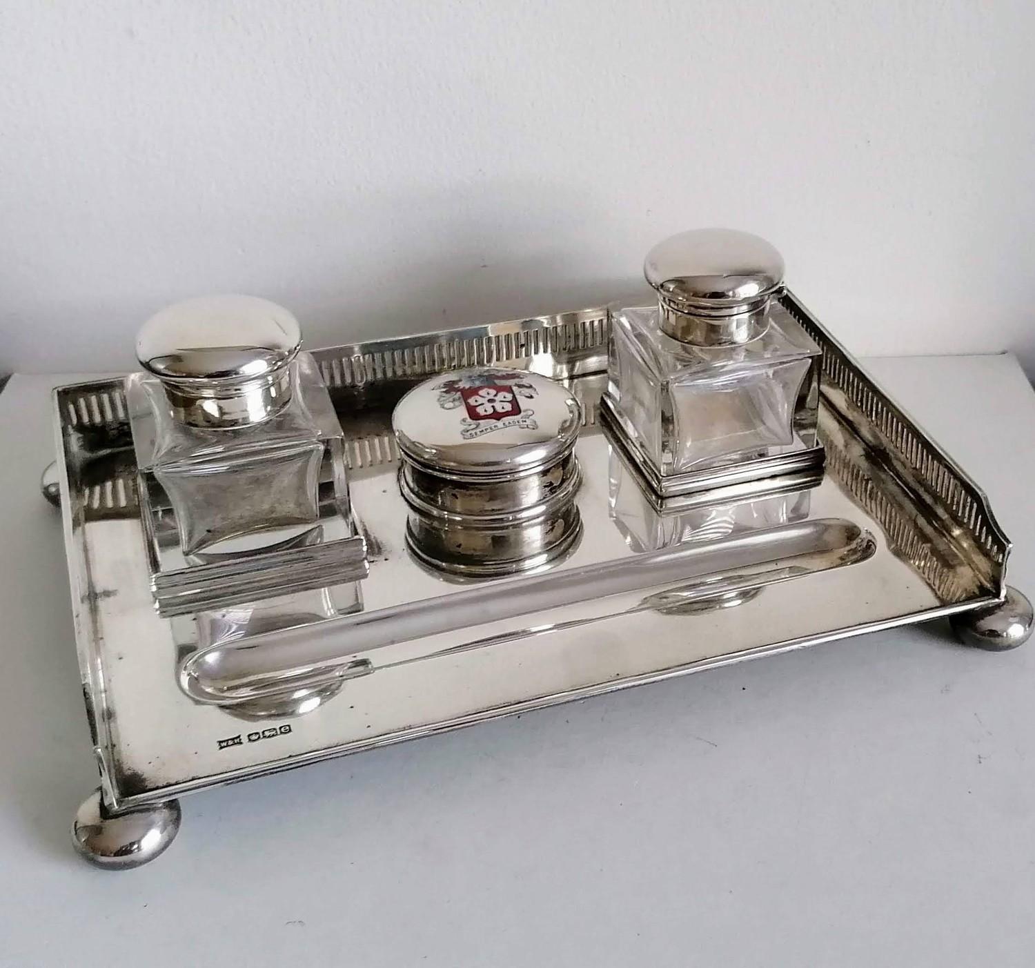 A George V silver ink stand with twin squared-based ink bottles, pierced gallery, enamelled