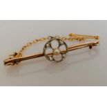 An Edwardian gold brooch with pearl and diamond decoration, safety chain, 4 cm, unmarked but tests