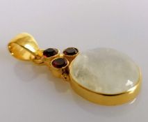 A silver-gilt set cabochon moonstone (16mm x 12mm) pendant with garnet decoration