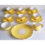 An Art Deco Aynsley lemon yellow butterfly-handle tea set comprising six teacups, saucers, side