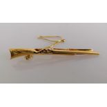 A yellow gold tie clip in the form of a rifle with safety chain, stamped 585, 6 cm, 6.78g