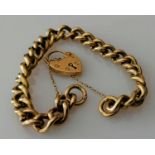 A 9ct yellow gold curb link bracelet with padlock clasp and safety chain, hallmarked, 34g