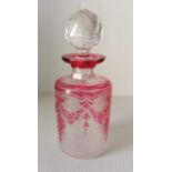 A Val St. Lambert etched cranberry glass cologne bottle with acid-cut rose wreath motif and
