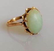 A 9ct yellow gold ring with an oval jade cabochon 15mm x 11mm in a claw setting, size S, marks