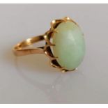 A 9ct yellow gold ring with an oval jade cabochon 15mm x 11mm in a claw setting, size S, marks