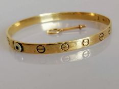 A 9ct yellow gold love bangle with key, import marks, 65mm x 55mm, 14.3g