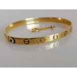 A 9ct yellow gold love bangle with key, import marks, 65mm x 55mm, 14.3g